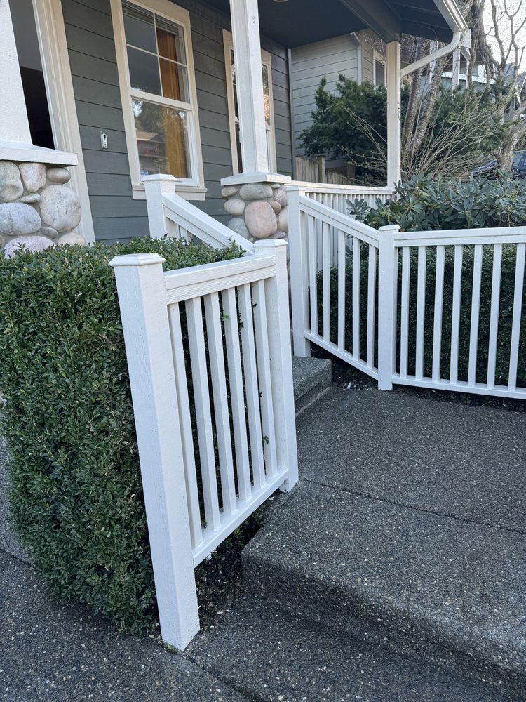 Freshly painted bright white porch railings and gate at the front steps after repainting