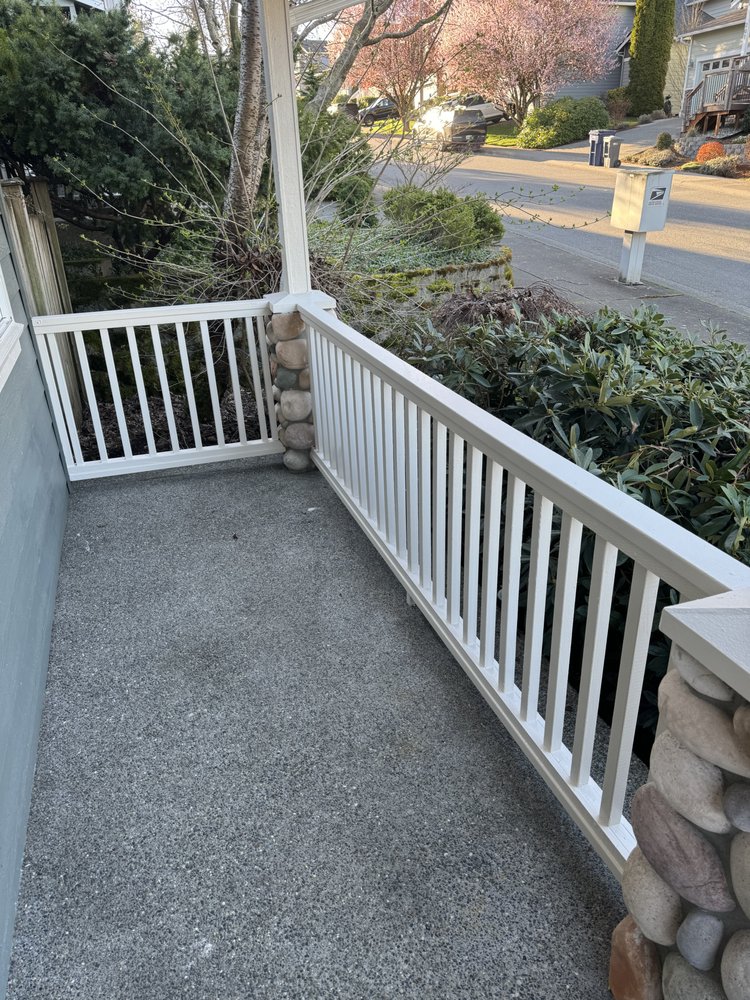 Finished white porch railing along the covered front porch after repainting
