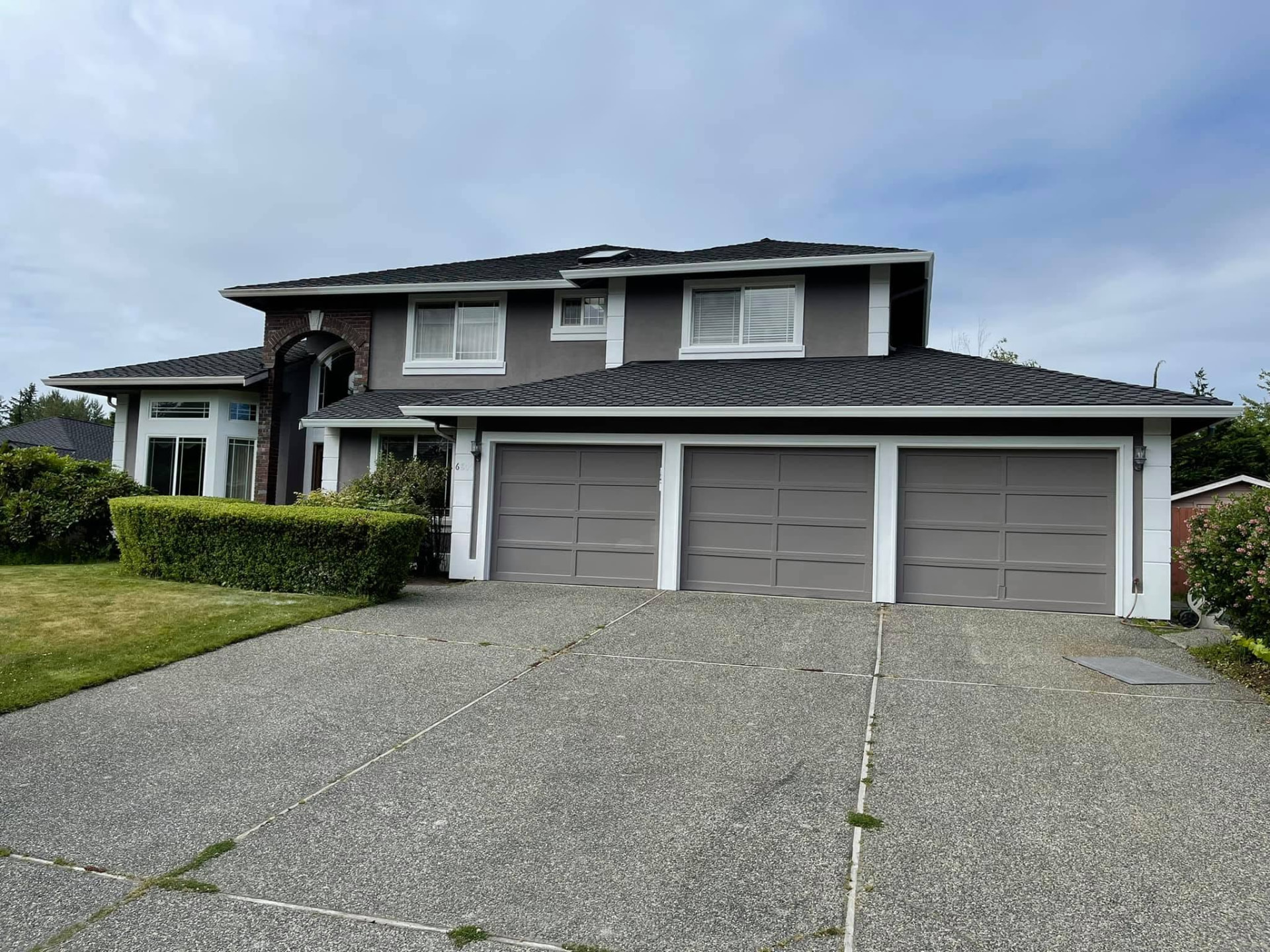 Same Everett home front elevation finished in warm gray siding with crisp white trim and repainted garage doors